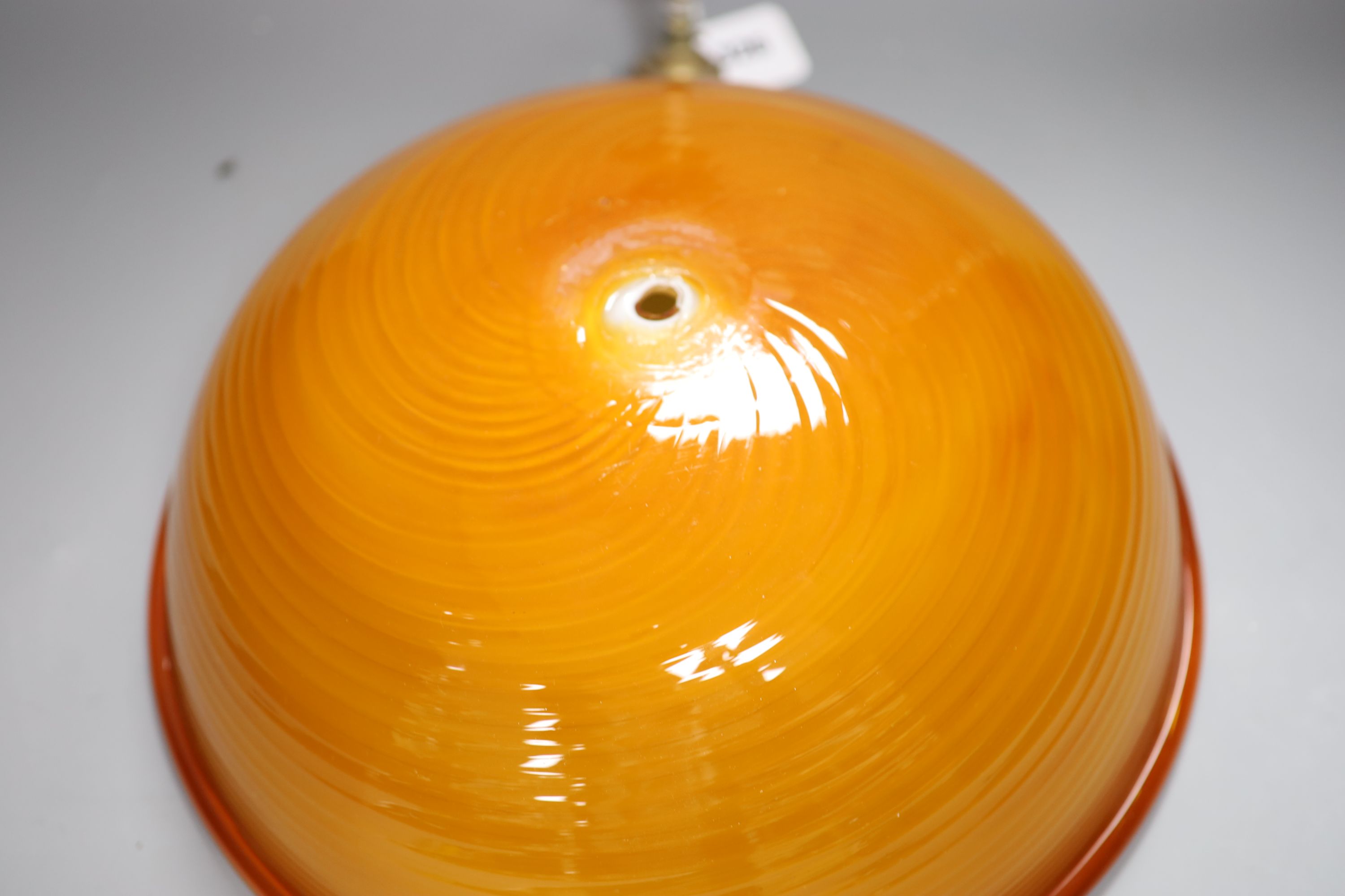 An Italian burnt orange glass circular ceiling shade